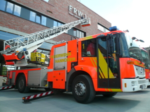Die Drehleiter der Feuerwehr unterstützt bei der Installation des Schriftzuges am neuen Wachgebäude