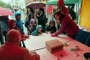 Kinder probieren gemeinsam mit Senioren das Murmelspielen aus.