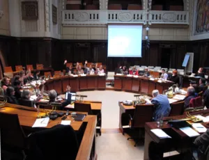 Die Ausschussmitglieder sitzen kreisf&ouml;rmig hinter Pulten im Hodlersaal. Einige heben die Hand zur Abstimmung.