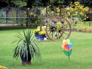 Ein mit Blumen geschm&uuml;cktes Holzrad im Park des Pflegezentrums Heinemanhof