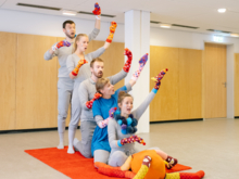 Fünf junge Menschen performen mit bunten Socken an den Armen