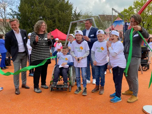Kinder und Erwachsene auf einem Spielplatz.
