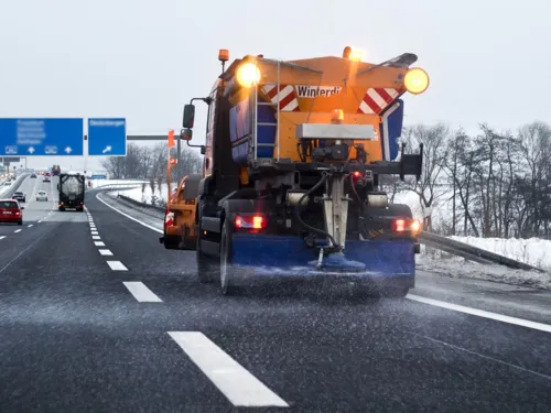 Ein Streufahrzeug auf einer Straße.