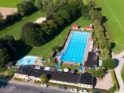 Luftbild vom Freibad mit Schwimmbecken, Kleinkindbecken, Geb&auml;uden und Liegewiese