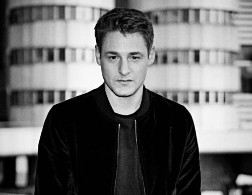 Brustbild eines Mannes mit kurzem Haar und ernstem Gesichtsausdruck