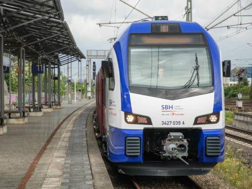 Eine blau-weiße S-Bahn steht an einem Bahnsteig.