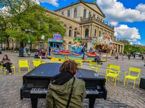 Mann spielt auf dem Outdoor-Klavier auf dem Opernplatz in Hannover.
