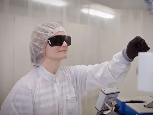 Frau mit Schutzbrille und medizinischer Schutzkleidung