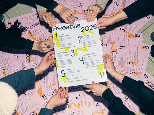 Viele Frauenhände halten ein Plakat für eine Ausstellungsankündigung fest