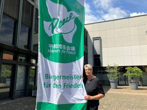 Bürgermeisterin Susanne Rutenkröger beim Hissen der Mayors for Peace Flagge vor dem Rathaus der Stadt Bünde.