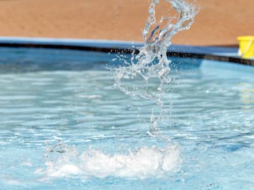 Wasser spritzt in einem Schwimmbecken.