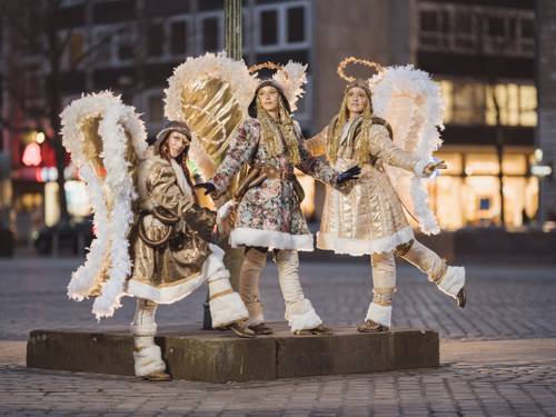 Drei als Engel verkleidete Menschen