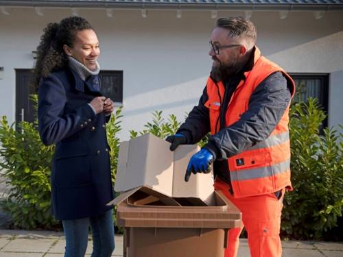 Eine Frau und ein Mann in Arbeitsuniform der Abfallwirtschaft der Region Hannover