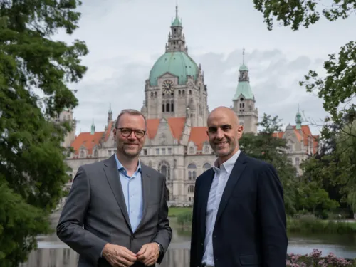 Zwei Männer im Park. In Hintergrund das Neue Rathaus von Hannover.