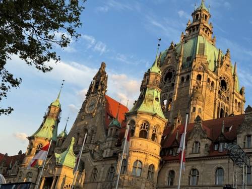 Ein Gebäude vor blauem, leicht bewölkten Himmel.
