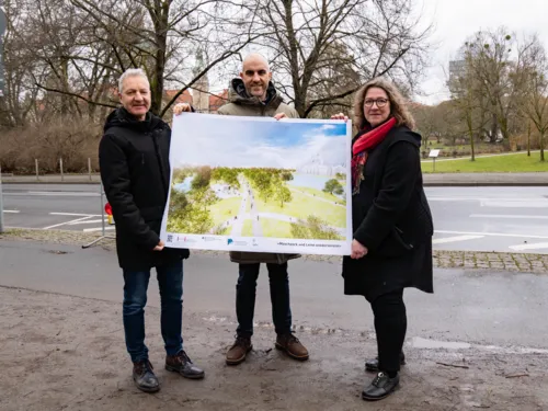 Drei Personen mit einer Visualisierung vor einem Park.