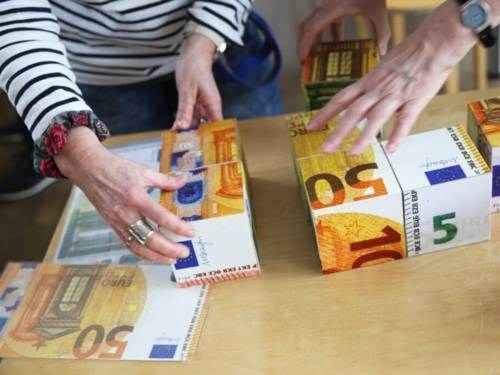 Zu sehen sind Spielklötze, auf denen Euroscheine gedruckt sind.