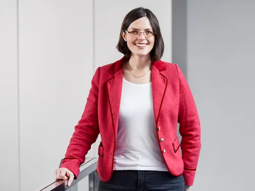 Portraitfoto einer Frau, die eine rote Jacke trägt