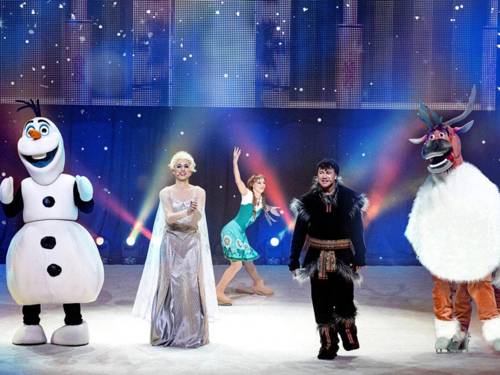 Auf einer Bühne sind ein Schneemann, ein Rentier sowie die Eiskönigin zu sehen.