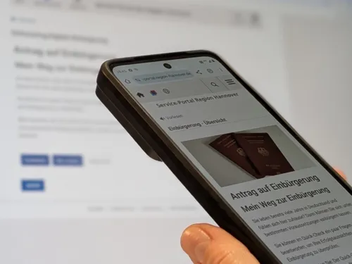 Ein Smartphone mit einer Anwendung vor einem Bildschirm