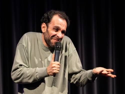 Zu sehen ist ein Comedian auf der Bühne.