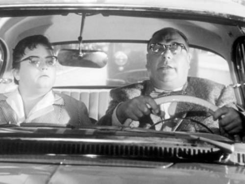 Mann und Frau in 1950er-Jahre Kleidung in einem Auto.