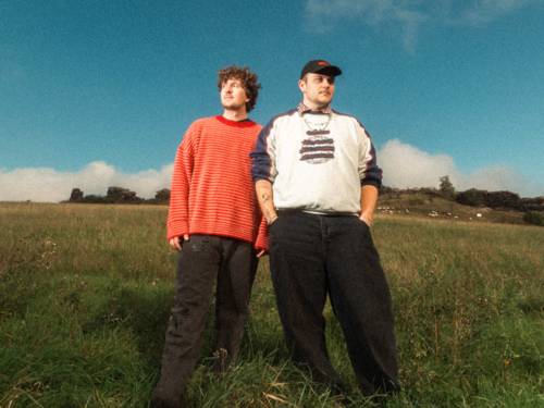 Die Brüder Ottolien posieren nebeneinander auf einem Feld.