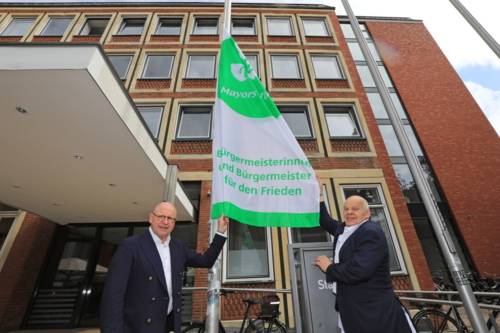 Oberbürgermeister Markus Lewe (l.) hisst gemeinsam mit Richard-Michael Halberstadt (friedenspolitischer Sprecher der CDU-Ratsfraktion) die Mayors for Peace Flagge vor dem Stadthaus Münster