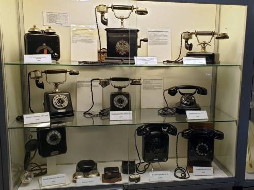 Zu sehen ist ein Schaukasten voller alter Telefonapparate.