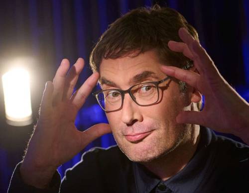 Mann mit kurzem Haar, Dreitagebart und Brille hält sich die Hände mit gespreizten Fingern seitlich an den Kopf.