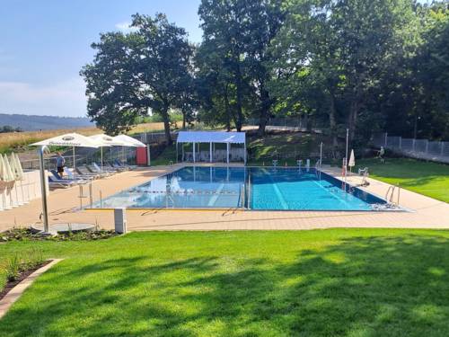 Freibad bei Sonnenschein, Rasen im Vordergrund, bei Sonnenschein