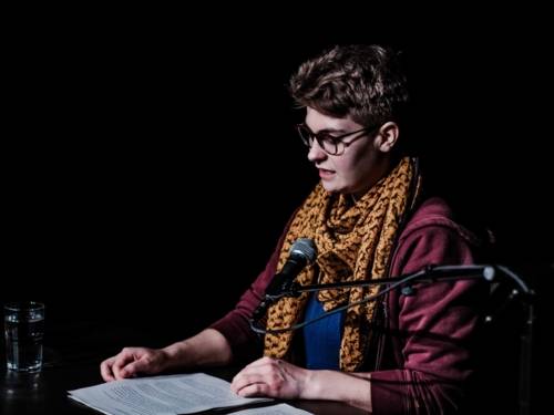 Eine Person liest auf der Bühne