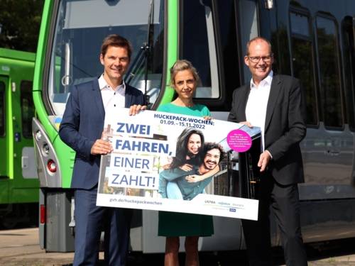 Steffen Krach, Elke van Zadel und Ulf-Birger Franz halten das Werbeplakat zur Huckepack Aktion der GVH