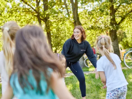 Menschen beim Sport auf einer Wiese.