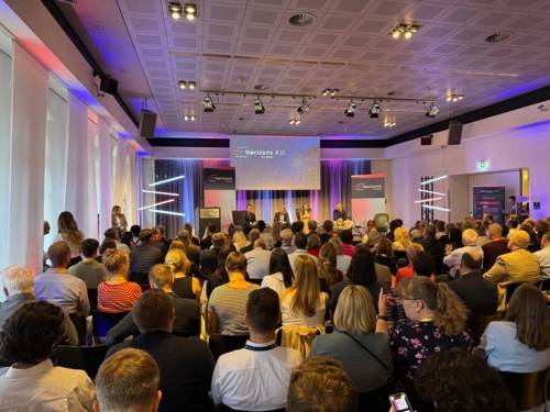 Menschen auf einem Podium vor Publikum.