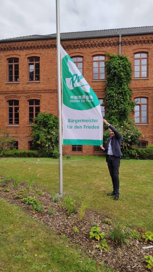 Osterholz-Scharmbeck: Bürgermeister Torsten Rohde zieht die Flagge der Mayors for Peace im Beisein der lokalen Presse hoch