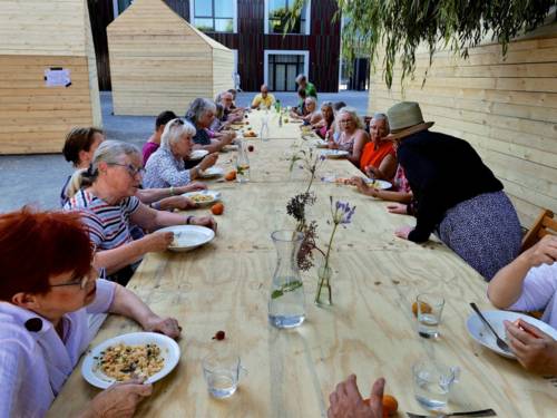 Menschen an einer langen gedeckten Tafel.