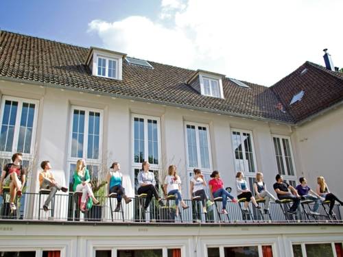 Jugendliche sitzen auf einem Geländer des Haus des Jugend
