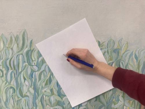 Hand mit Stift die auf ein weißes Blatt schreibt