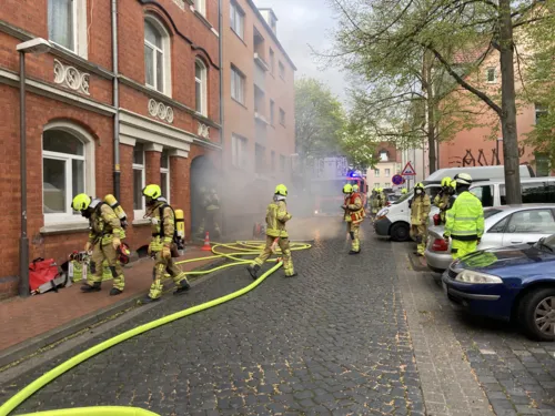 Brandrauch strömt aus einem Hauseingang.