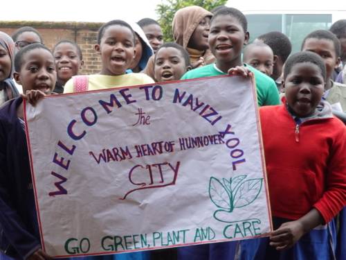 Schüler*innen der Nayizi Primary School begrüßen die Delegation aus Hannover