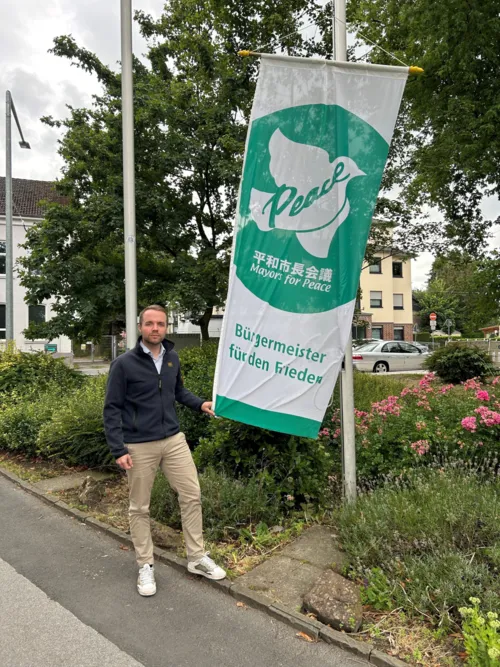 Bürgermeister Marcel Mittelbach beim Hissen der Flagge Mayors for Peace am Morgen des 8. Juli 2025 vor dem Waltroper Rathaus