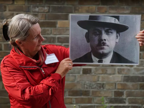 Stadtführerin hält ein Porträtfoto von Fritz Haarmann hoch.
