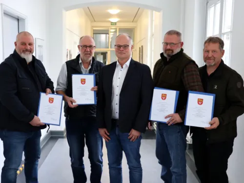 Fünf Männer, vier mit Urkunden