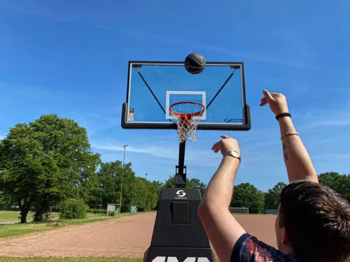 Eine Person, die einen Basketball auf einen Korb wirft.