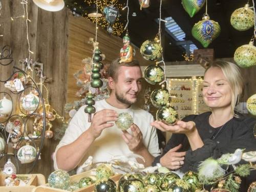 Eine Frau und ein Mann mit Christbaumschmuck.