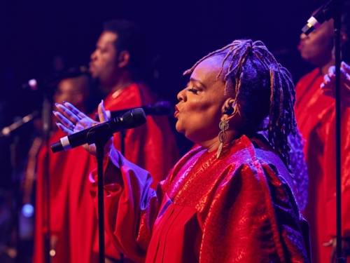 Zu sehen sind Schwarze Gospel-Sängerinnen und -Sänger der Gruppe „The Harlem Gospel Singers“.