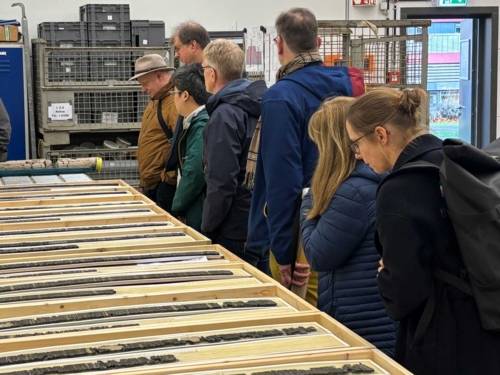 Menschen blicken auf Bohrkerne.