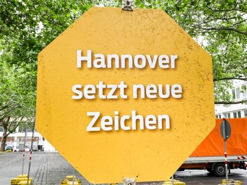 Ein gelbes Schild, auf dem "Hannover setzt neue Zeichen" steht.