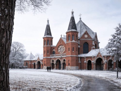 Ein Friedhof im Winter von außen. Davor eine Rasenfläche.